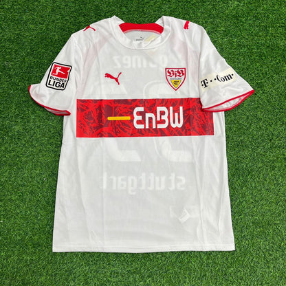 White sports jersey with red and black details on a green grass background – Jersey Paradise Edition